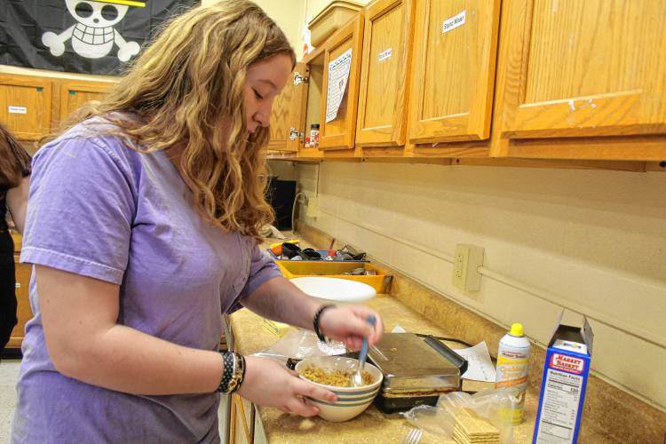 Khloe Bennett of Jaffrey works on a meal at a prep counter.