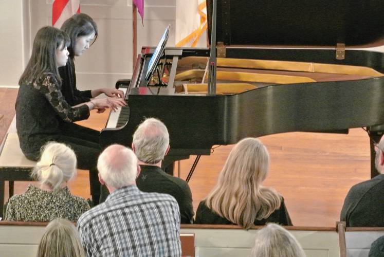 Pianists Cynthia Tseng (left) and Pualina Lim (right) perform piano four-hand compositions.